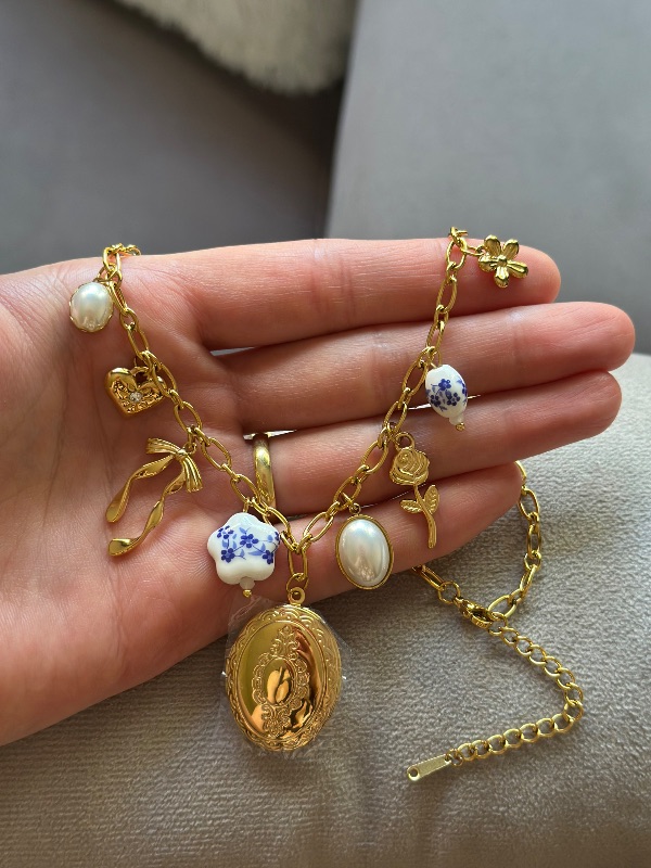 Collar relicario con dijes - Acero 316L
con enchapado en oro.