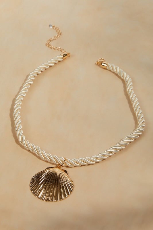 Collar de cordón con dije de concha
dorada
