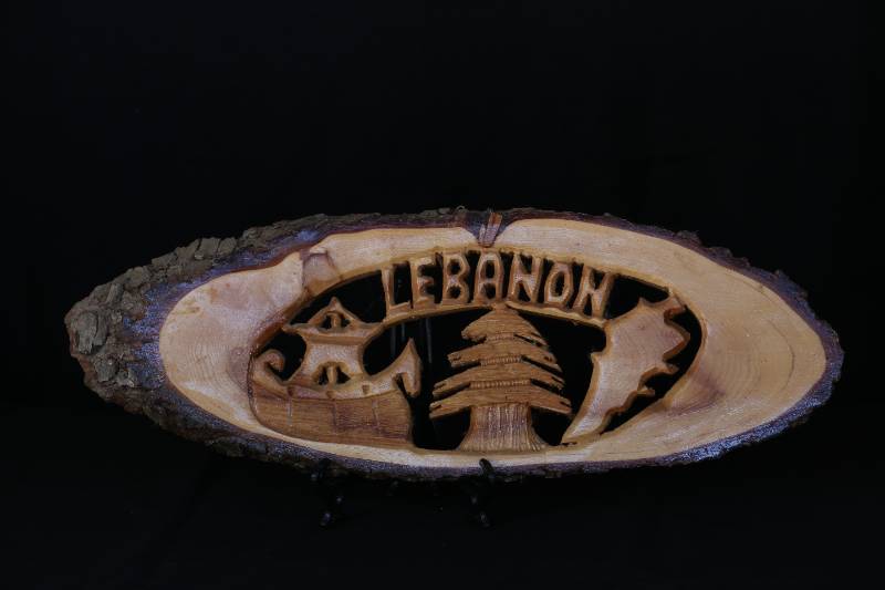 Hand-Carved Wooden Plaque – “LEBANON” with Cedar Tree and Heritage Motifs
لوحة خشبية محفورة يدويًا – "LEBANON" بتصميم أرز وشخصيات رمزية