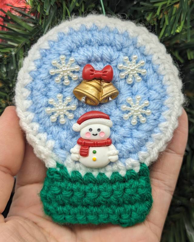 Crochet Snowglobe Ornament (A) - Green base: Red/White Snowman with Golden Bell/Red Bow and 4 Snowflake icons in Globe