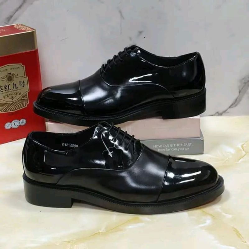 Fosco, en cuir verni noir, avec un laçage et un bout droit.