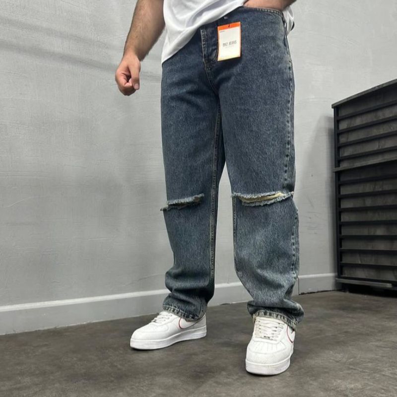 jeans de style "boyfriend" avec une coupe ample, une taille basse à moyenne, et des déchirures.