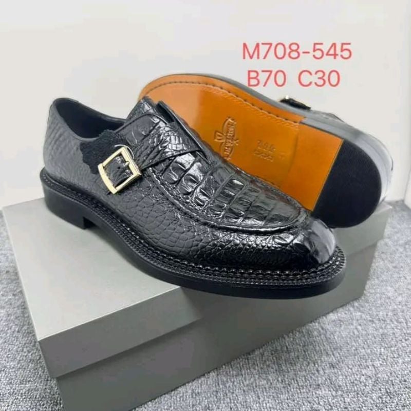 mocassins J.M. Weston en cuir noir à motif crocodile avec une boucle dorée.