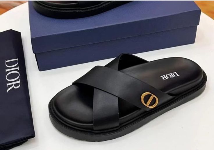 Dior en cuir noir avec un design à brides croisées et une boucle dorée.