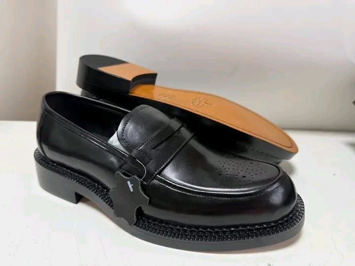 mocassins penny loafers en cuir noir avec une semelle épaisse et crantée.